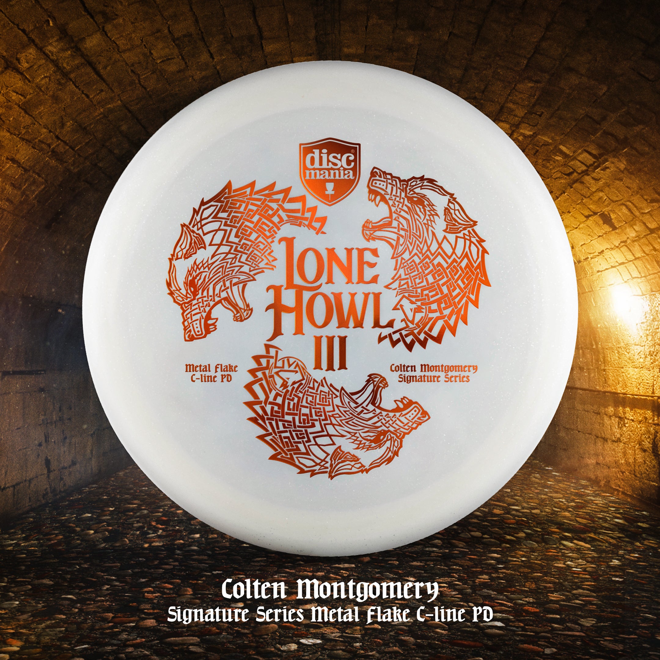 Transparent white Discmania PD Power Driver disc, made from C-Line Metal Flake plastic blend, with bronze Colten Montgomery Lone Howl foil stamp